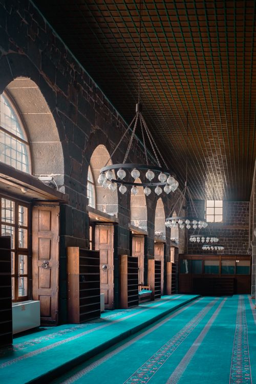 Free Elegant interior of a historical building with wooden furnishings and arched windows, creating a warm and inviting atmosphere. Stock Photo