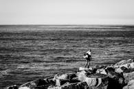 一位孤独的渔夫站在海边，捕捉到了宁静而沉思的时刻