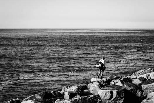 一位孤独的渔夫站在海边，捕捉到了宁静而沉思的时刻