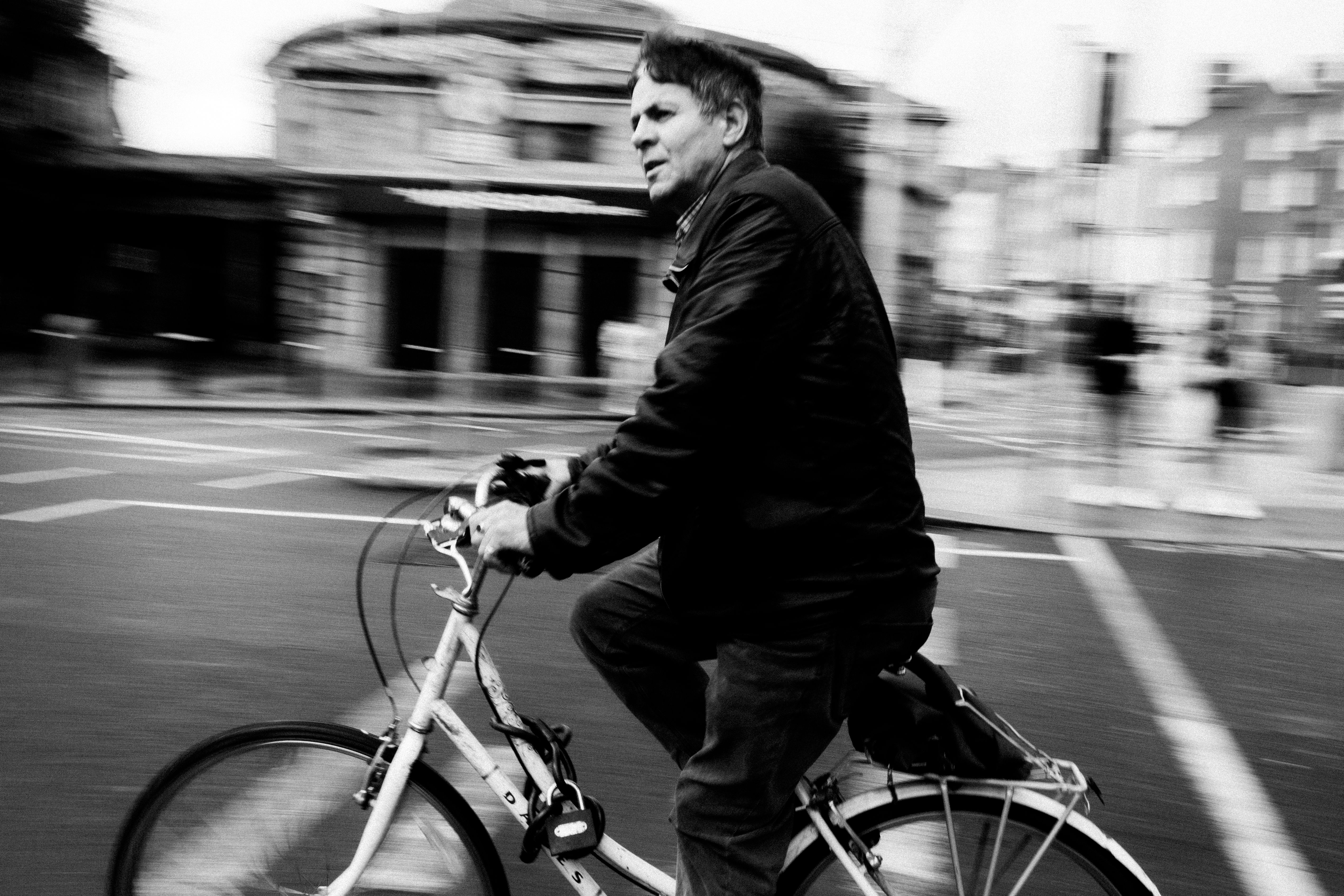 Dynamic black and white photo of a cyclist in motion along the streets of Dublin, Ireland.