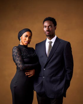 在温暖的背景前，时尚情侣穿着精致的正式服装