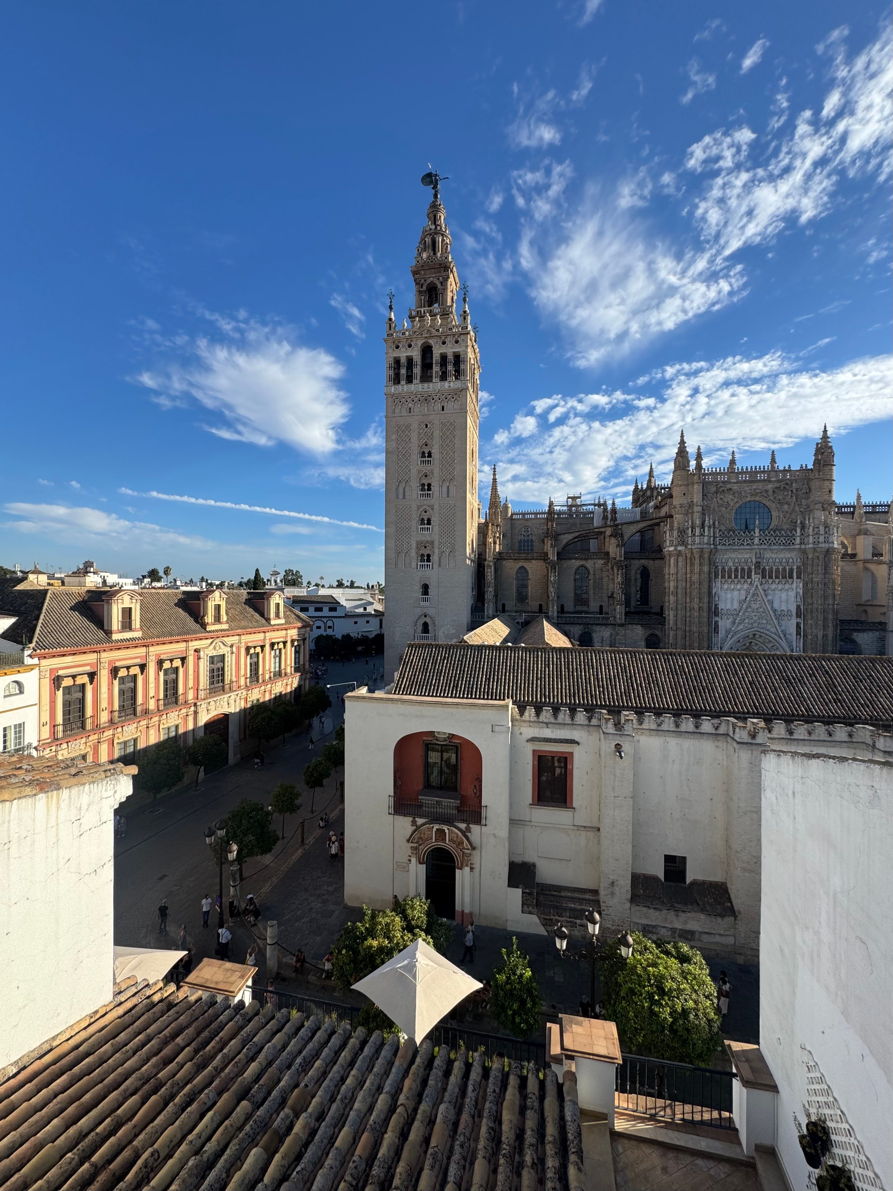 Giralda Tower and Seville Cathedral under bright blue skies.