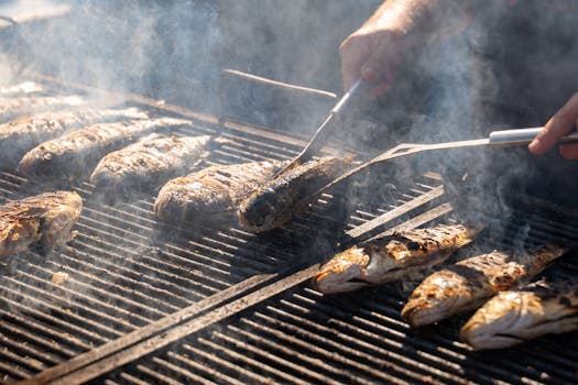 Juicy grilled fish sizzling on a barbecue with smoky flavor outdoors.