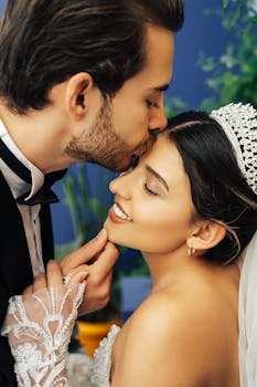 A loving groom kisses his smiling bride's forehead on their wedding day in Antalya, Türkiye.