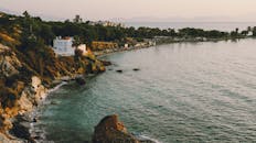 日落时分，海岸边展现出迷人的美景：悬崖峭壁与平静的海面交相辉映，营造出宁静的氛围