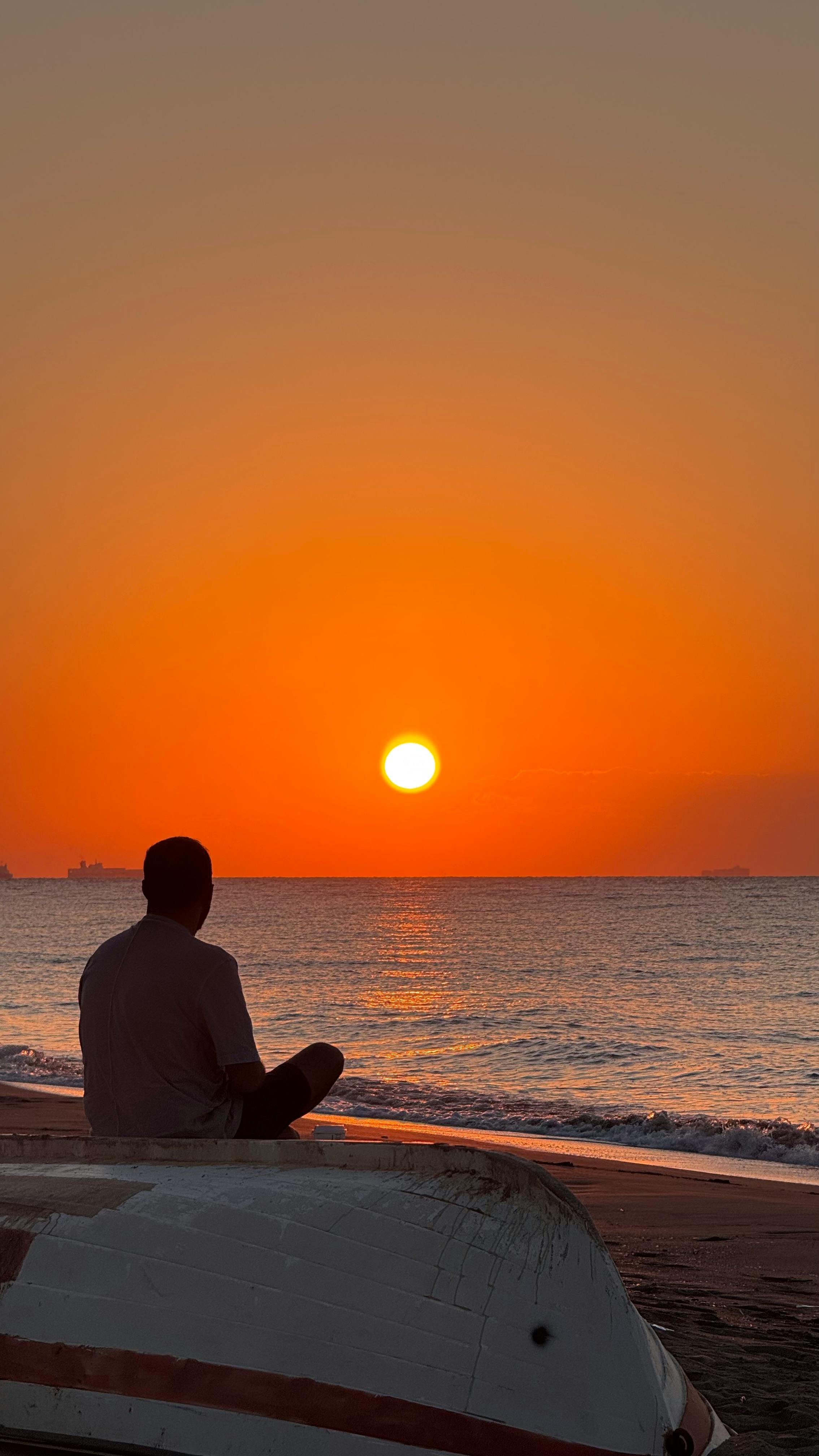 日落时分，一个人在海滩上冥想，欣赏宁静的海景