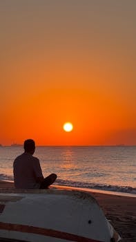 日落时分，一个人在海滩上冥想，欣赏宁静的海景