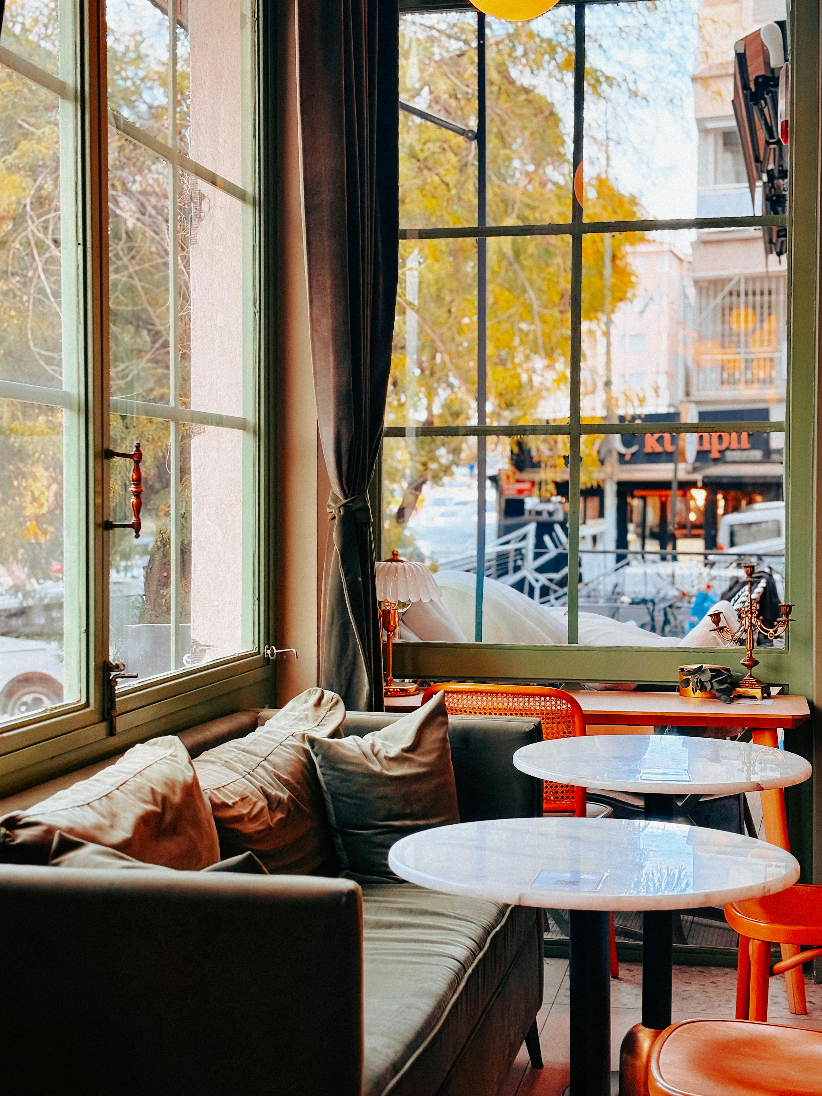 Gratuit Interiorul unei cafenele însorite, cu scaune confortabile și vedere la stradă, perfect pentru relaxare. Fotografie de stoc