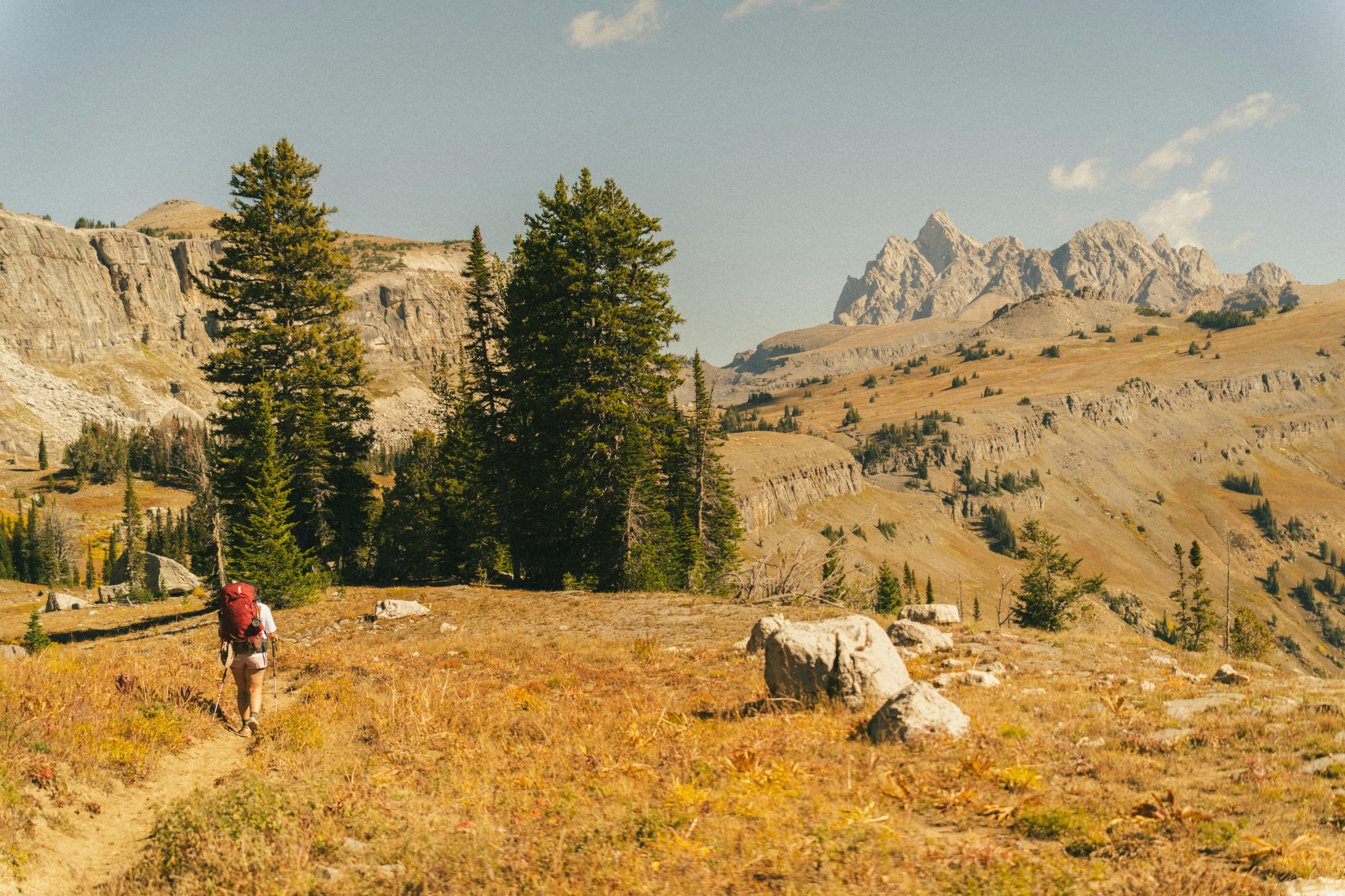 Hiker with backpack exploring the scenic mountains of Grand Teton National Park.