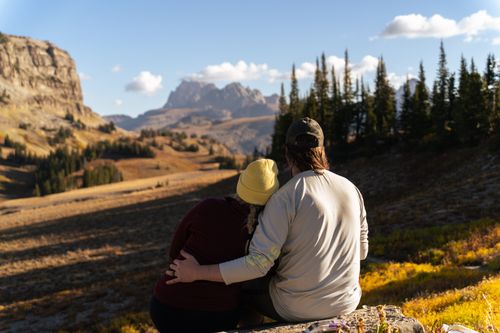 Free A couple embraces while enjoying a scenic mountain view at Grand Teton National Park, Wyoming. Stock Photo