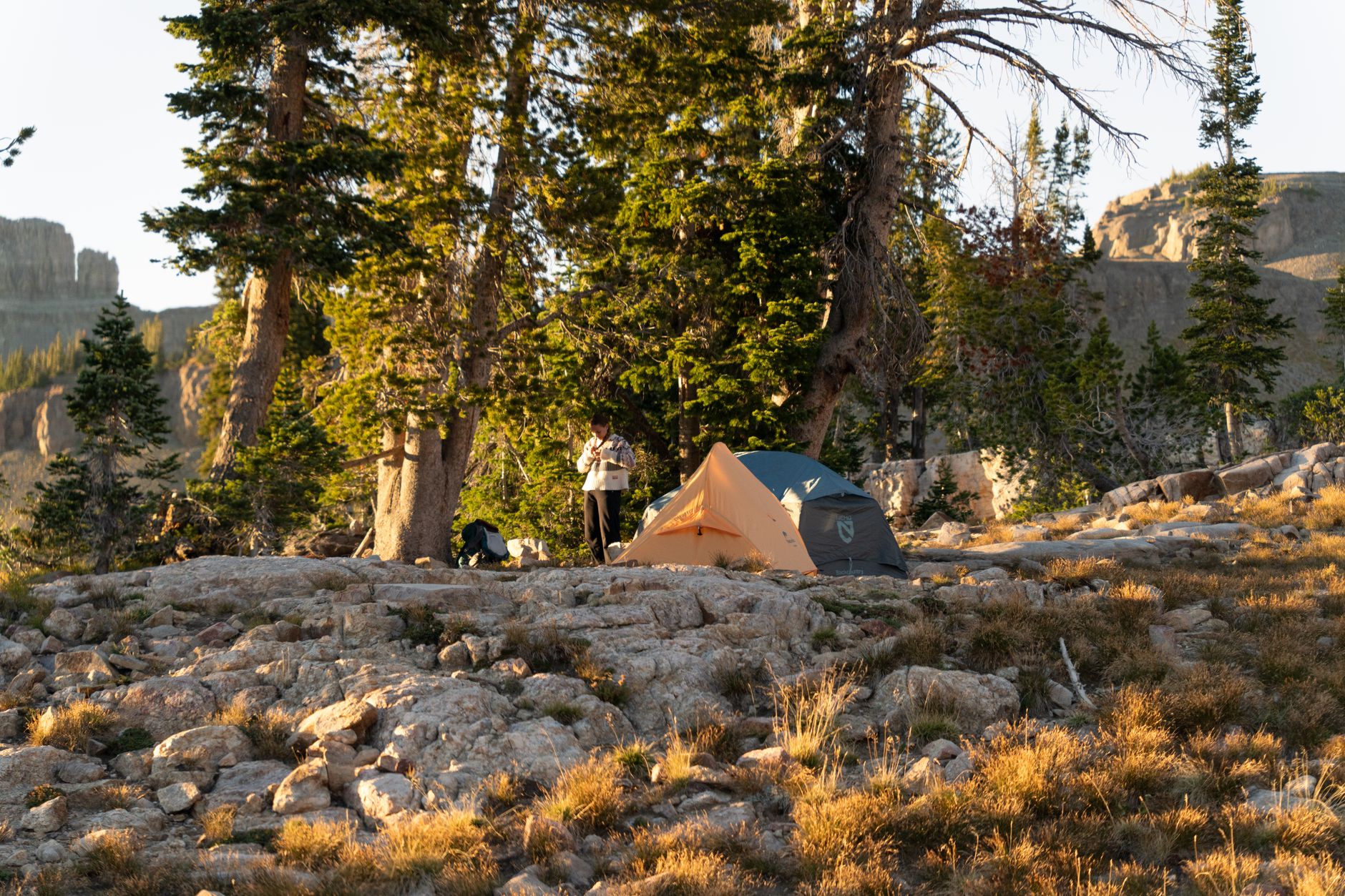 hiker setting up tent wilderness