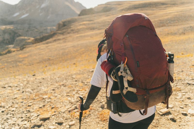 Backpacker with gear on Teton Crest Trail in Wyoming's wilderness.