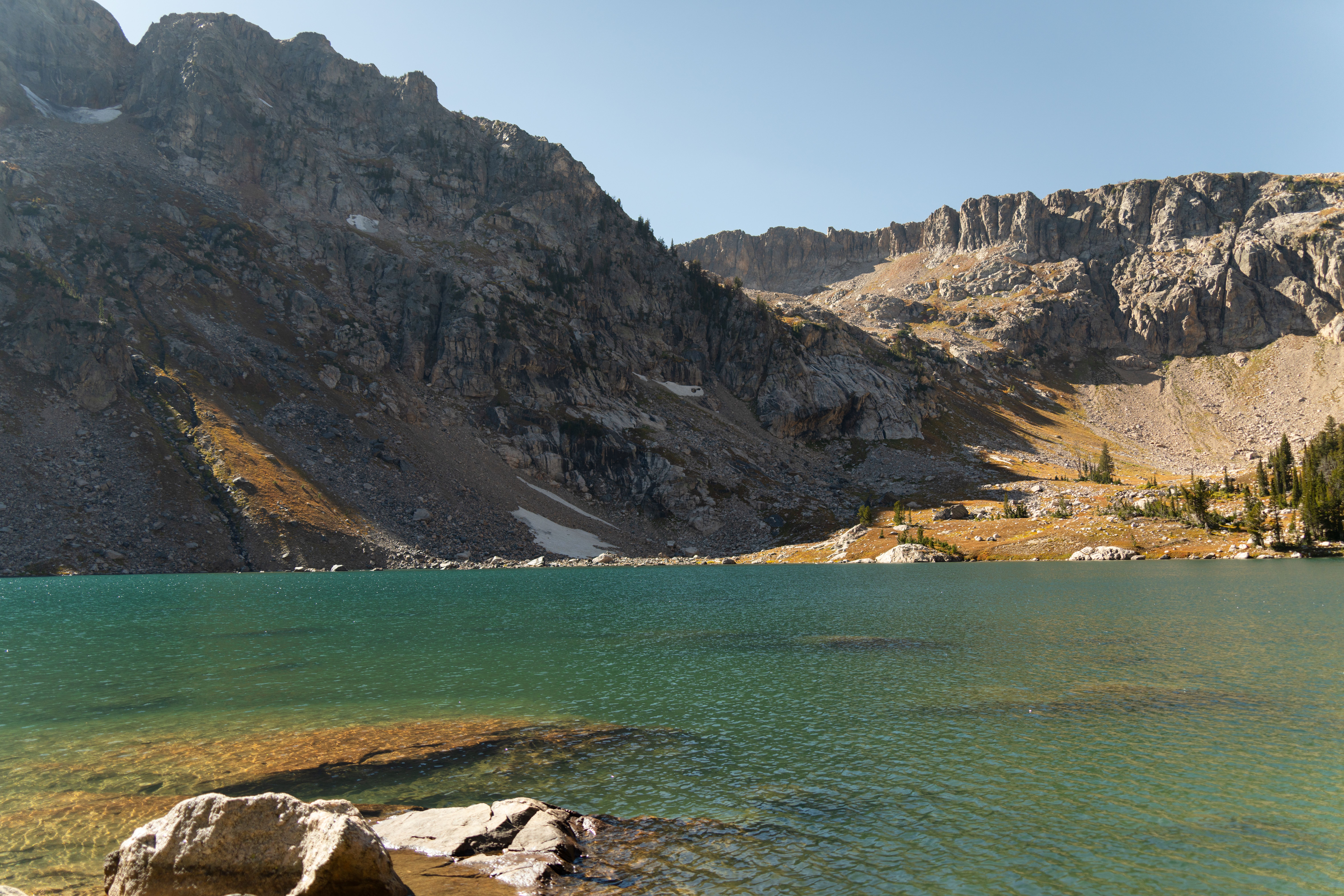 Breathtaking view of an alpine lake surrounded by rugged mountains in Grand Teton National Park, Wyoming.