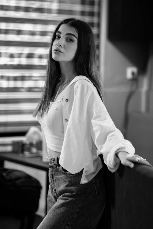 Free Stylish black and white portrait of a young woman posing indoors with a confident look. Stock Photo