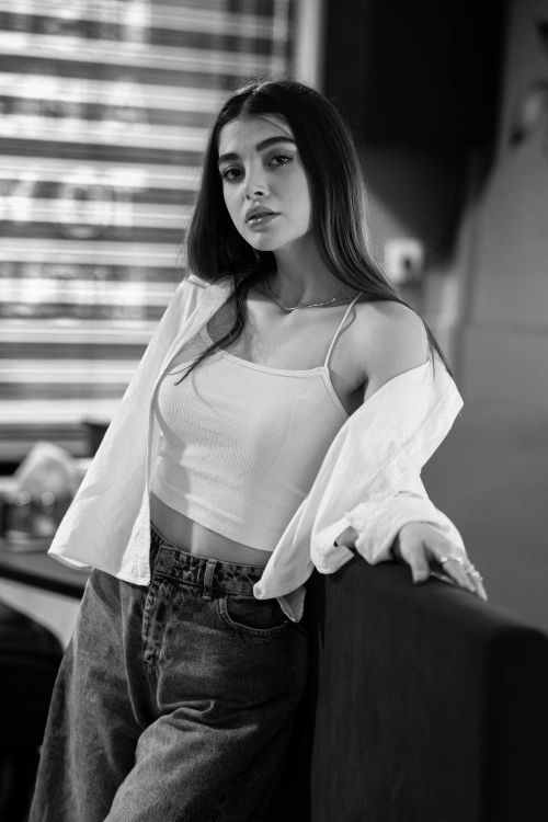 Free Elegant black and white portrait of a young woman posing indoors. Stock Photo