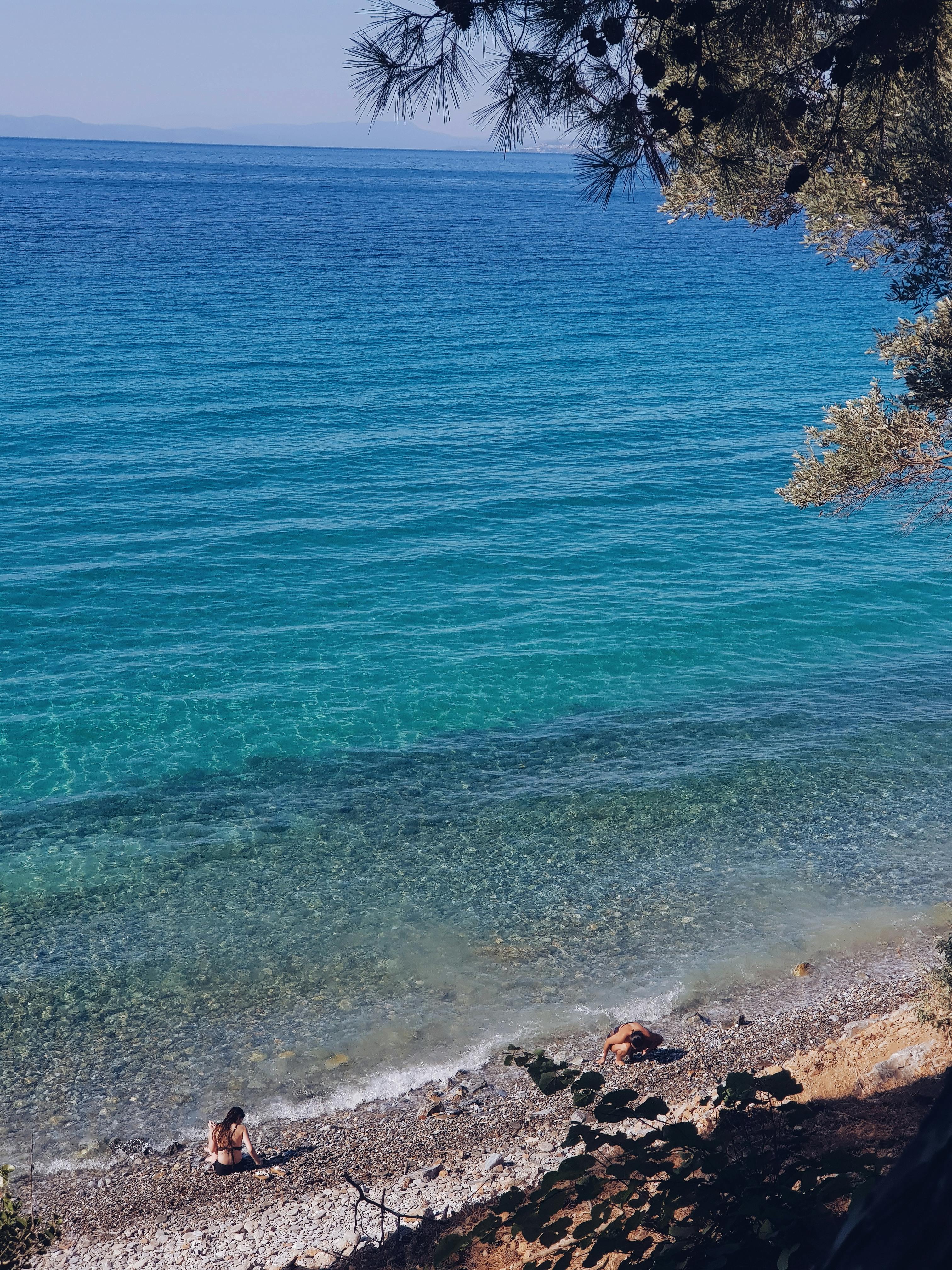 在蓝天下，大海显得格外平静，岩石海岸的景色令人感到放松