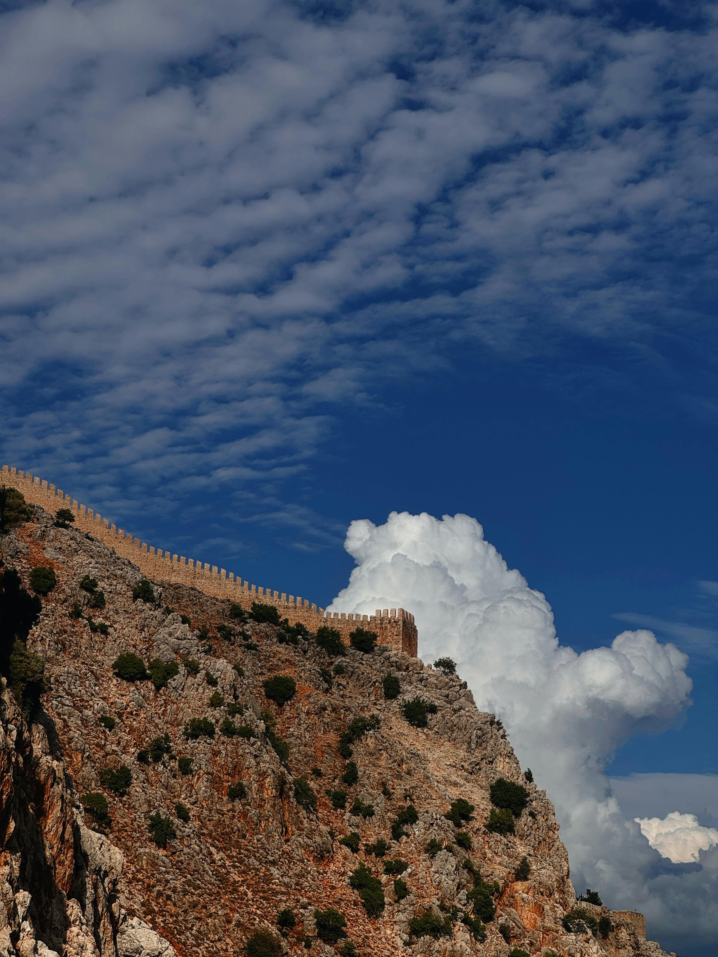 在土耳其明亮的蓝天下，岩石悬崖上古老城堡墙壁的壮丽景色