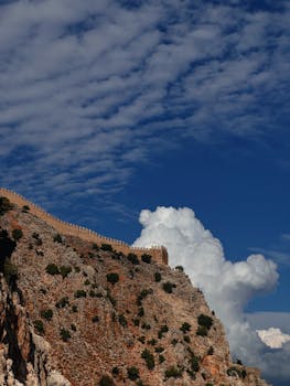 在土耳其明亮的蓝天下，岩石悬崖上古老城堡墙壁的壮丽景色