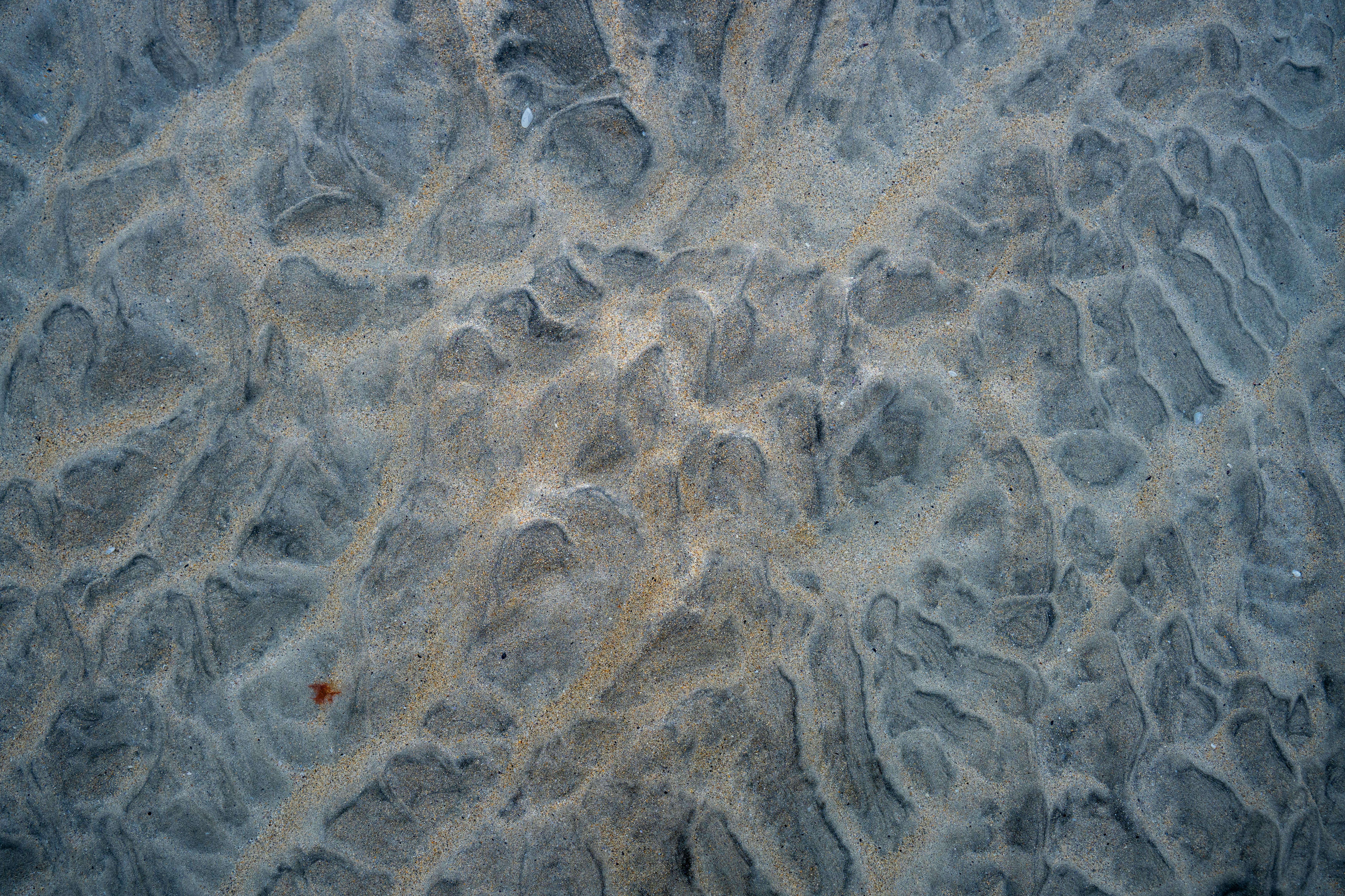 Gratuit Gros plan des motifs de sable naturels sur la plage de Harris, en Écosse, présentant des textures complexes. Photos