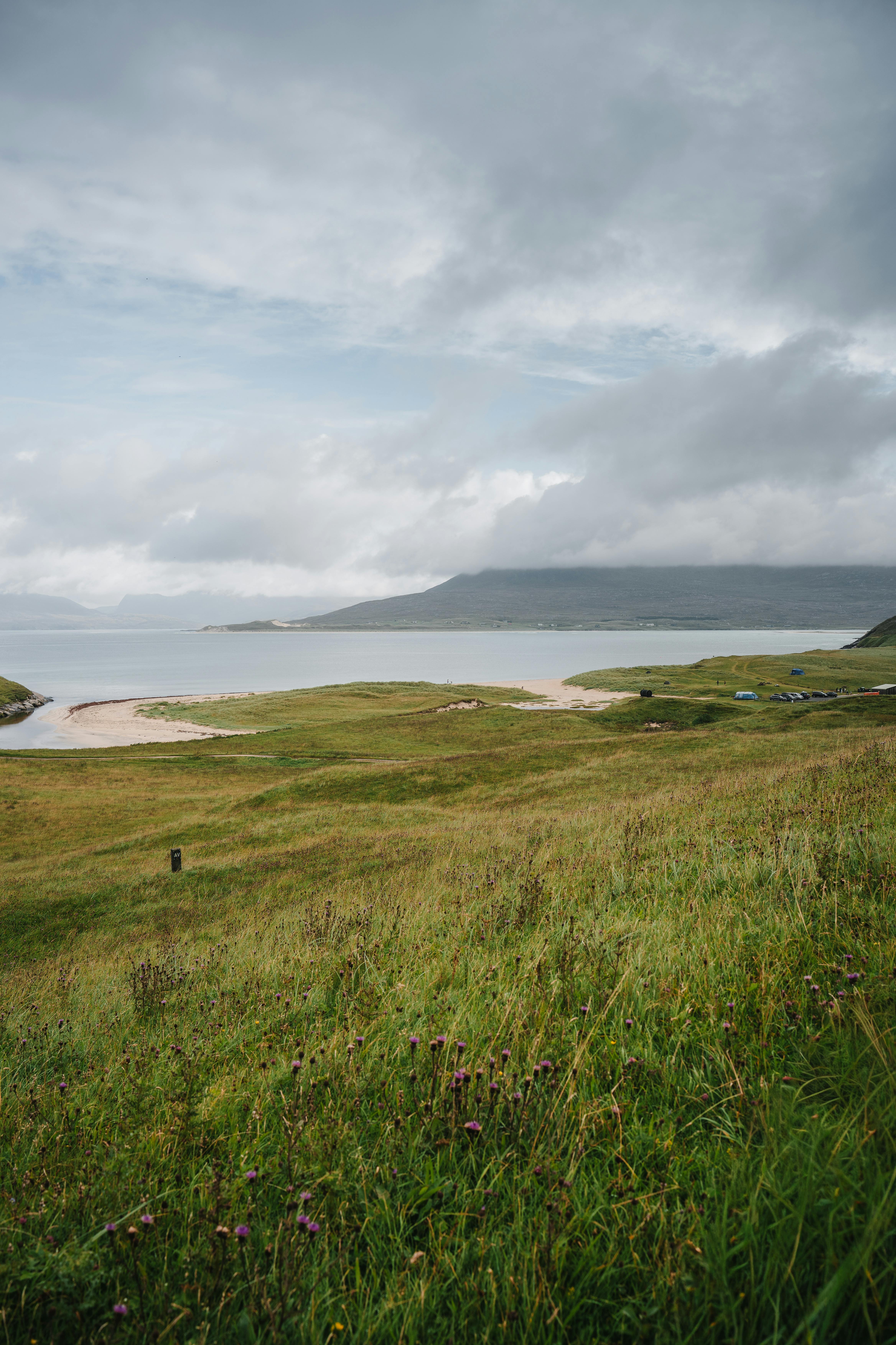 在多云的天空下，苏格兰哈里斯的海岸线和连绵起伏的山丘令人惊叹不已