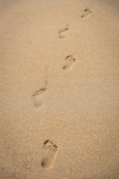 足迹在阳光明媚的沙滩上划过，捕捉到了苏格兰哈里斯的宁静