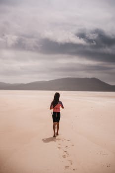 孤独的人影，漫步在苏格兰勒斯肯泰尔海滩上，周围是广阔而宁静的景象