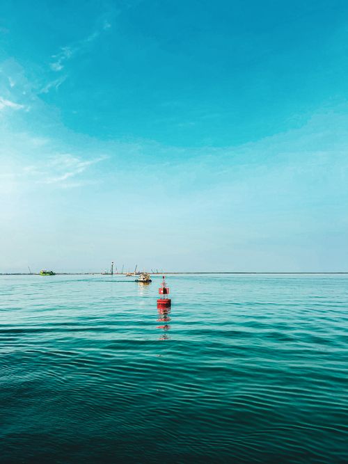 Free A serene ocean scene featuring a buoy under a bright blue sky, creating a calming atmosphere. Stock Photo