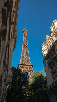 A stunning view of the Eiffel Tower framed by Parisian buildings on a clear day.