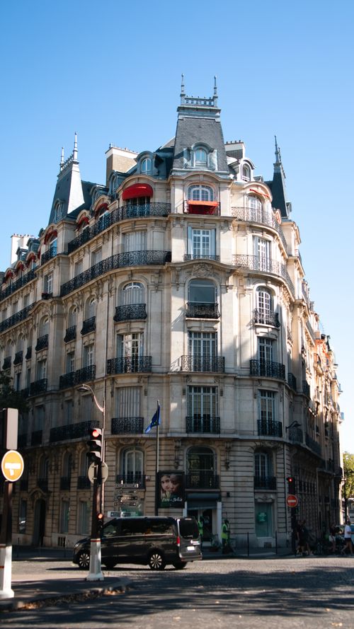 Free Haussmannian building under clear blue sky in central Paris, showcasing iconic French architecture. Stock Photo