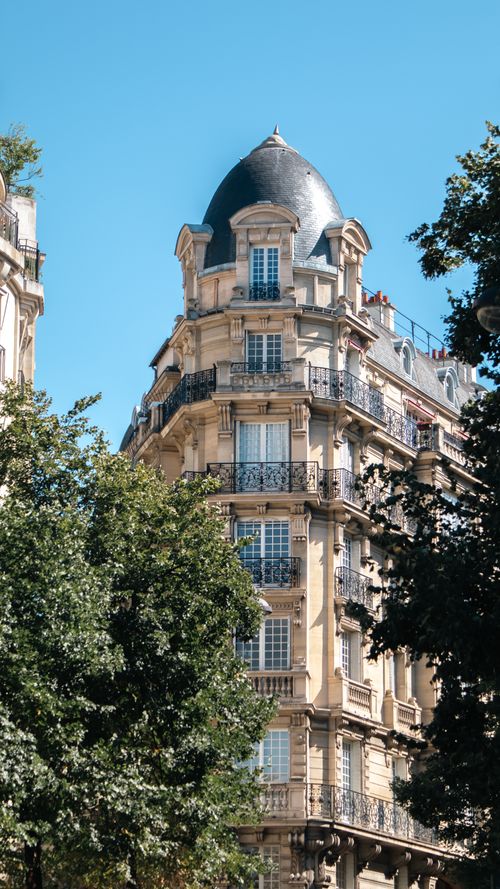 Free Elegant Parisian building against a clear blue sky, showcasing classic architecture. Stock Photo