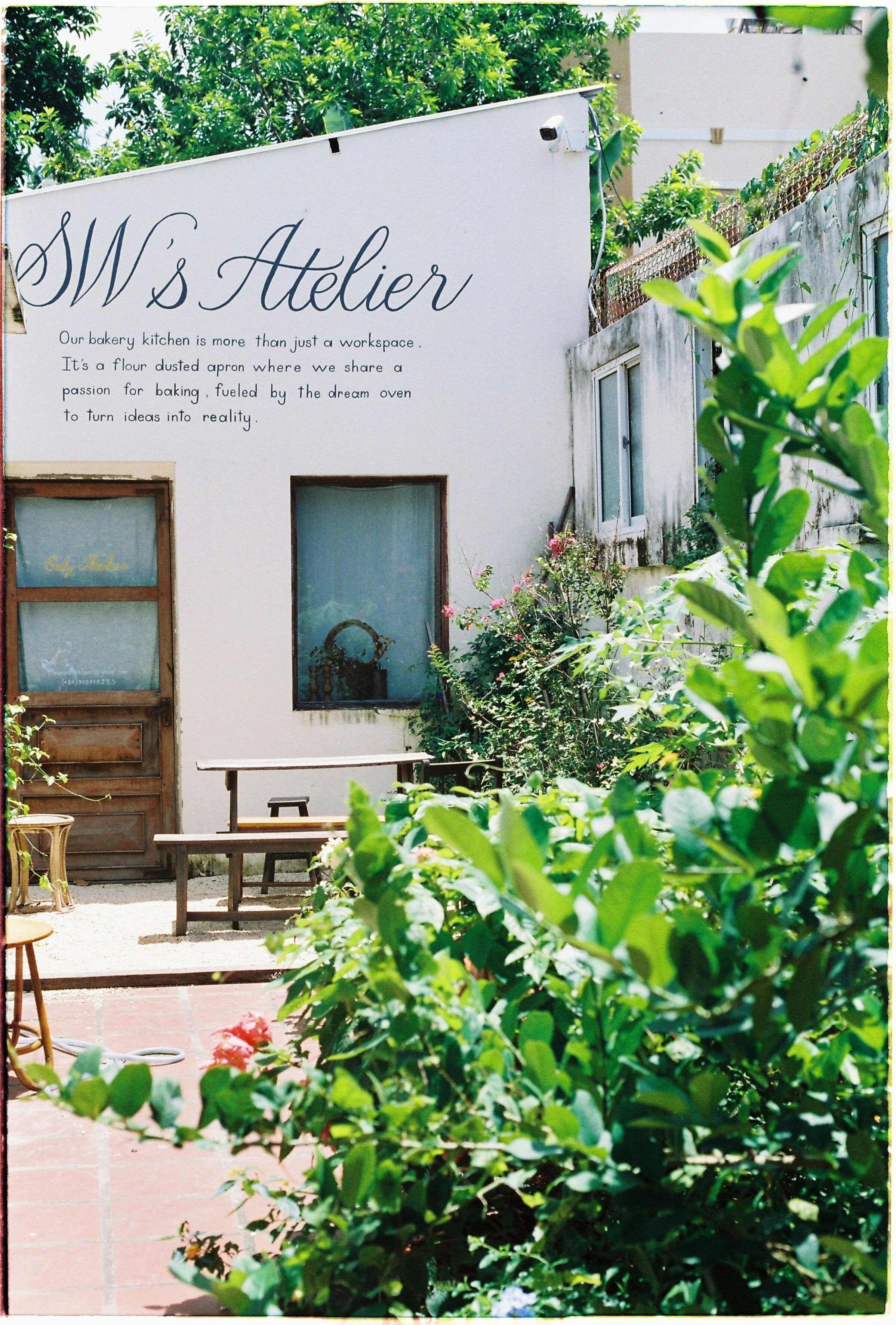Charming café with garden path, rustic décor, and green plants on a sunny day.
