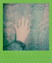 复古风格的即时照片显示，一只布满尘土纹理的手与绿色边框相映成趣