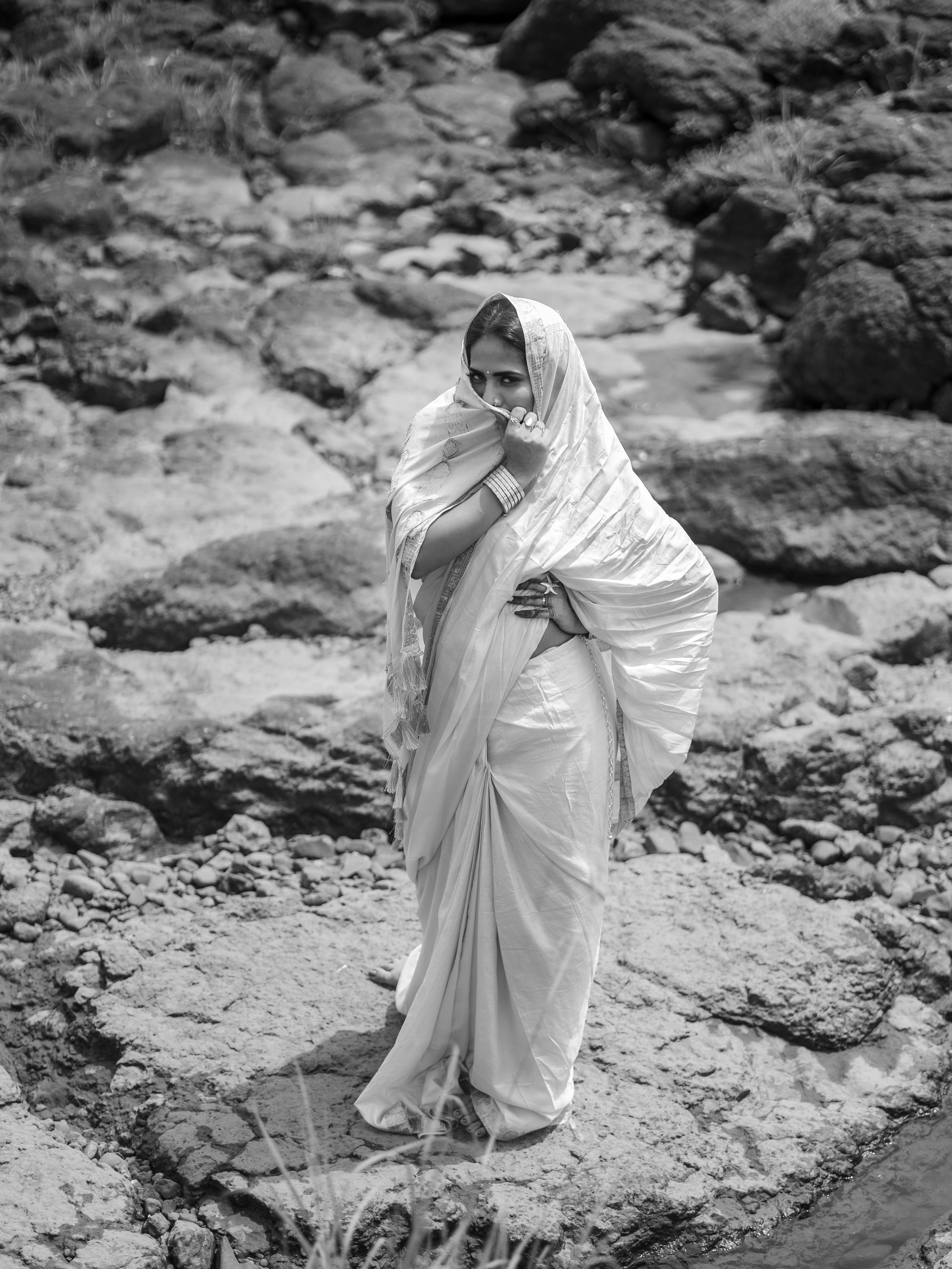 一位穿着传统莎丽的女性在岩石地形上的优雅肖像