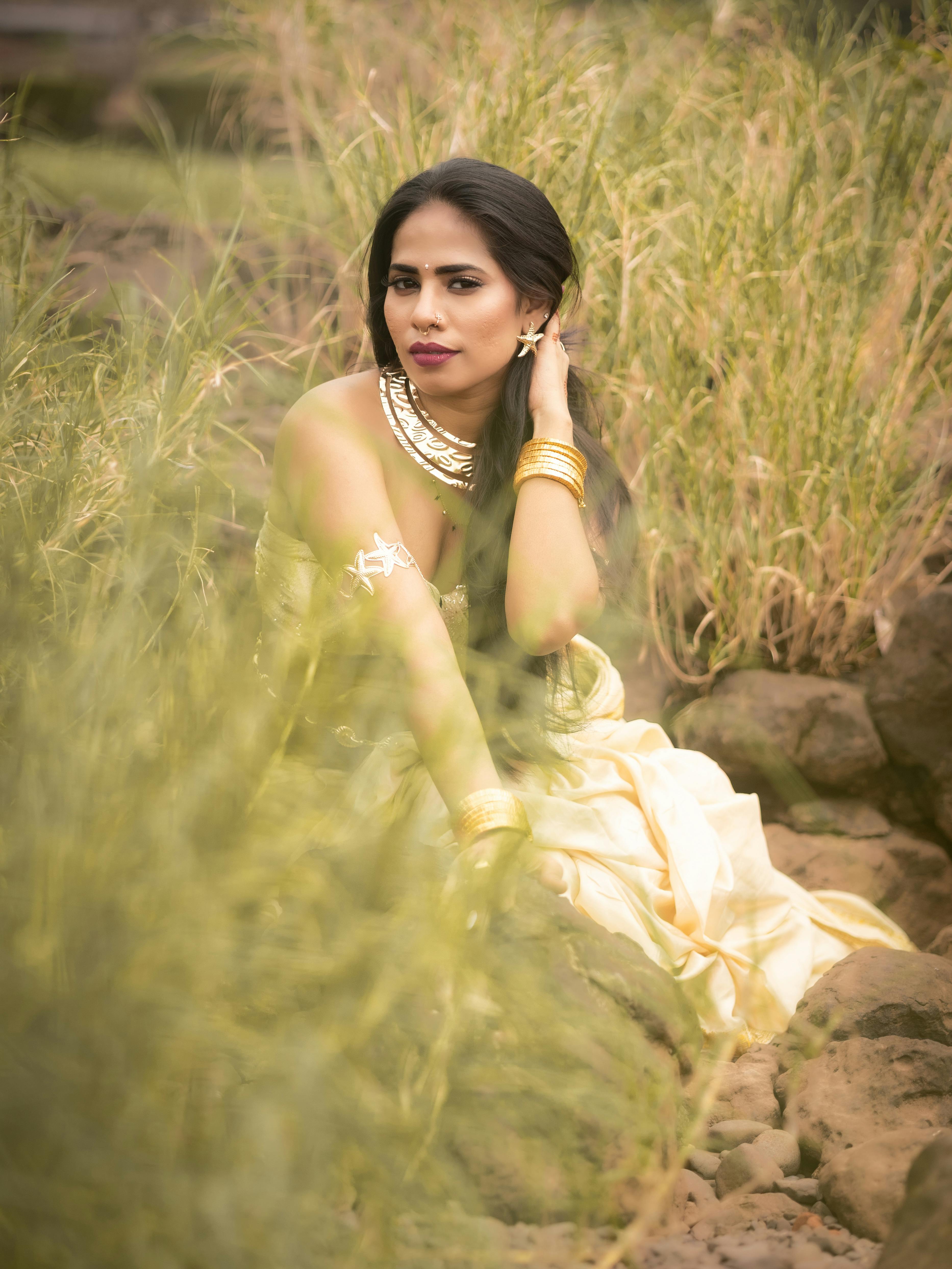 身着传统服饰的优雅女子在郁郁葱葱的自然环境中摆姿势