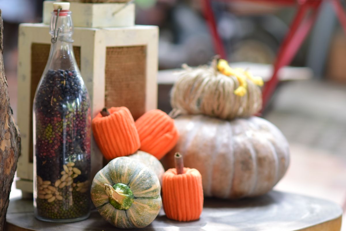 Rustic autumn display with pumpkins and a bottle on a wooden table