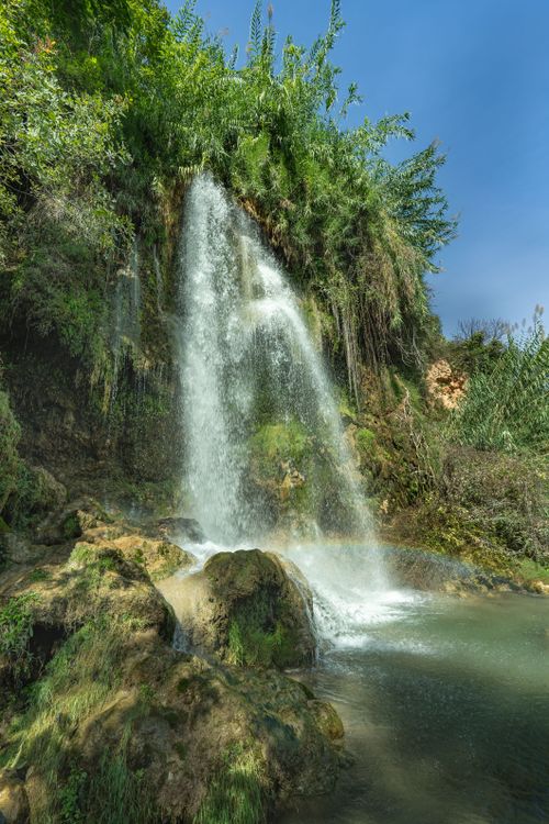 Free A tranquil waterfall cascading in the lush greenery of Anna, Comunidad Valenciana, Spain. Stock Photo