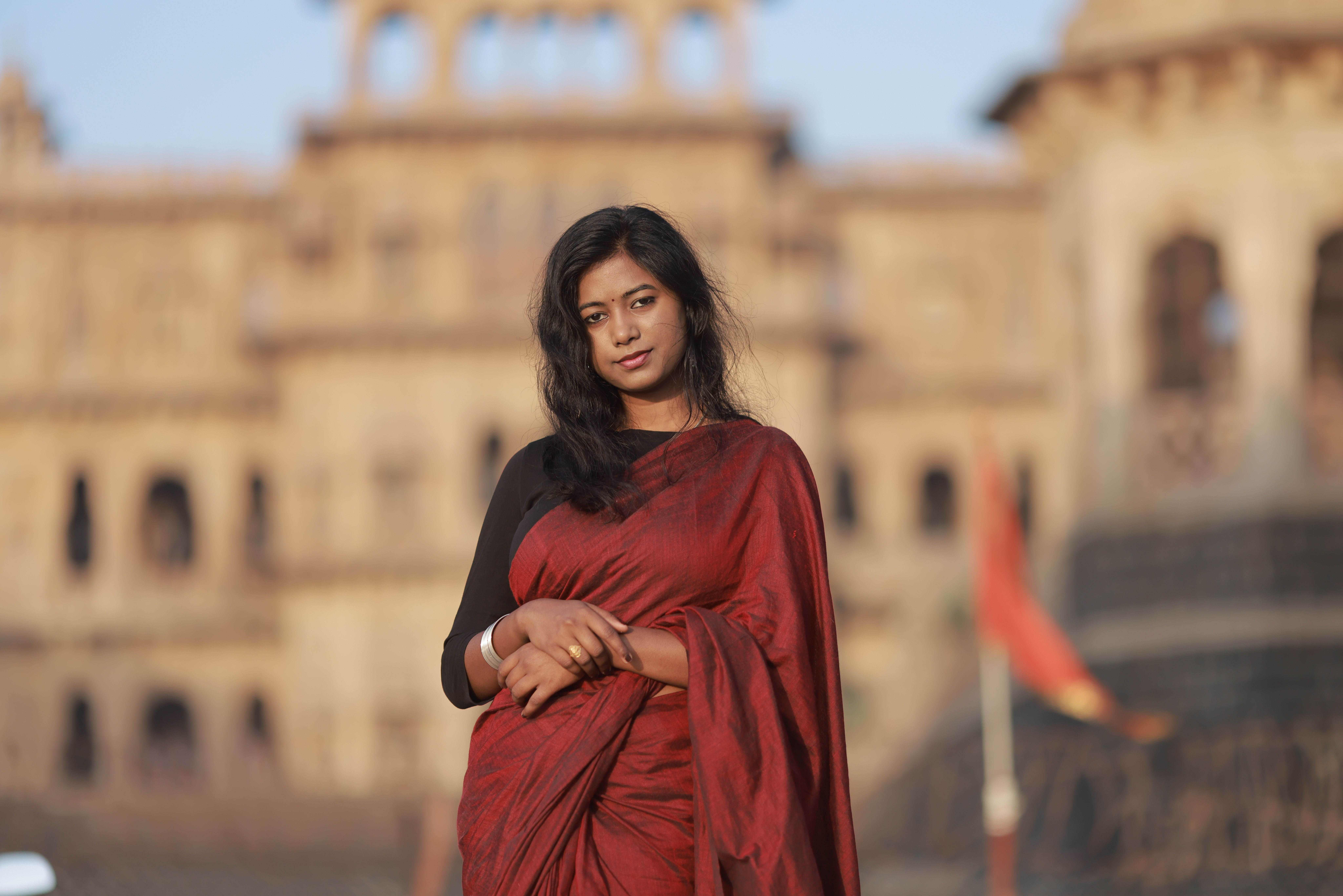 Elegant Woman in Red Saree at Historic Landmark · Free Stock Photo