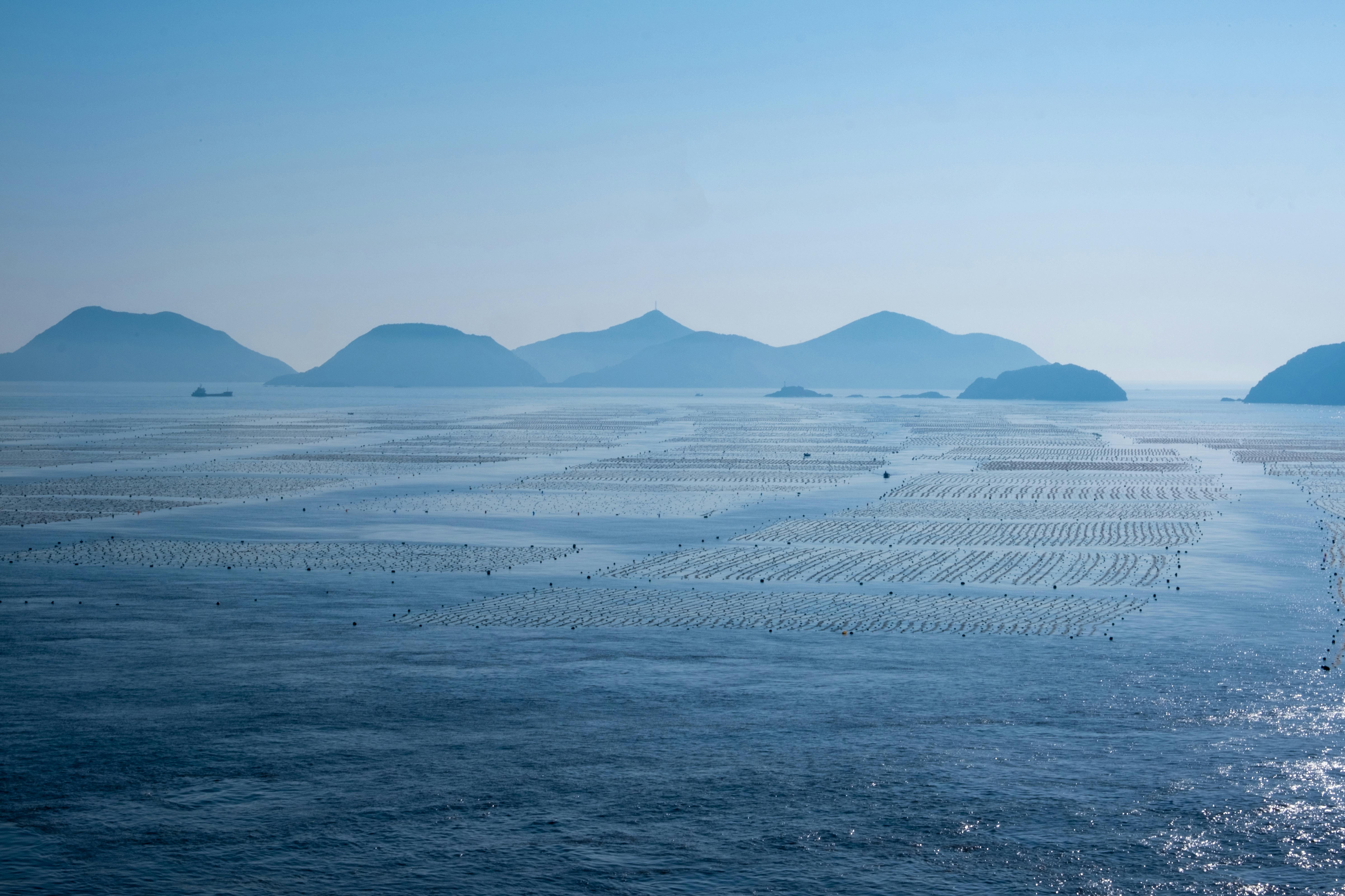 在蔚蓝的天空下，宁静的海景中点缀着岛屿和平静的海水