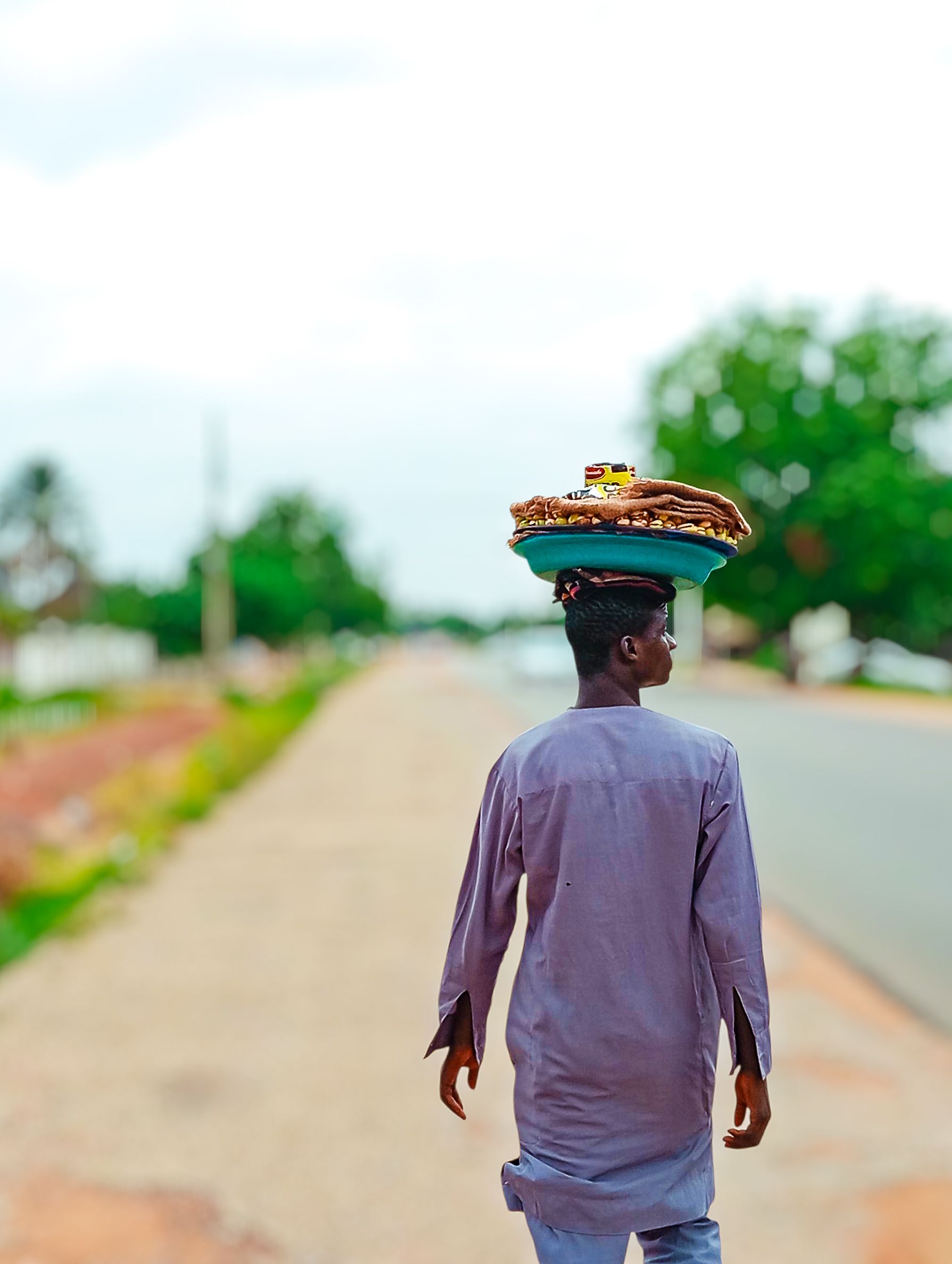 Street Vendor in Jimeta, Nigeria Balancing Goods · Free Stock Photo
