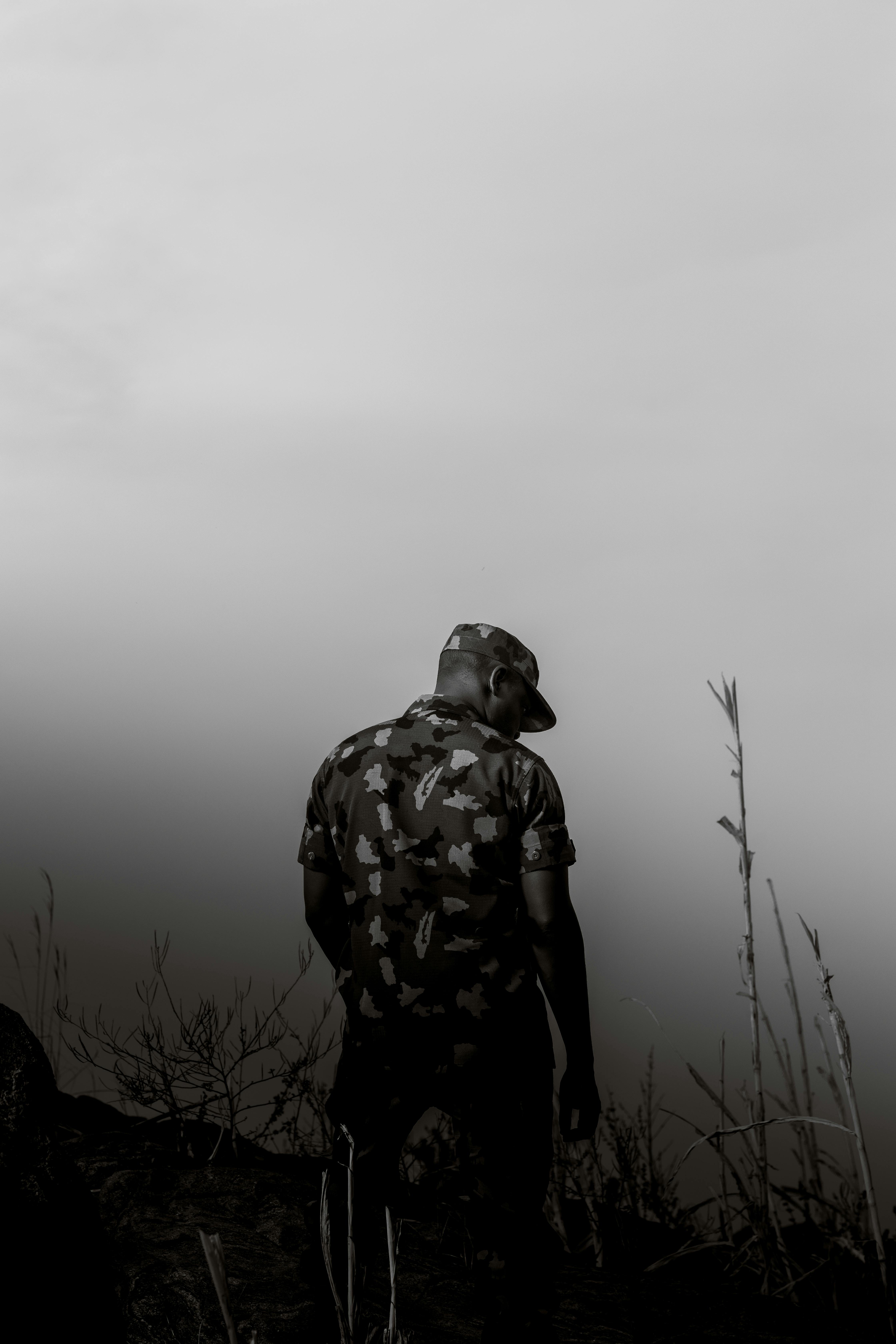 bezplatná Osamělá postava vojáka v uniformě stojí zamyšleně na pozadí zatažené oblohy v Abuji v Nigérii. Základová fotografie