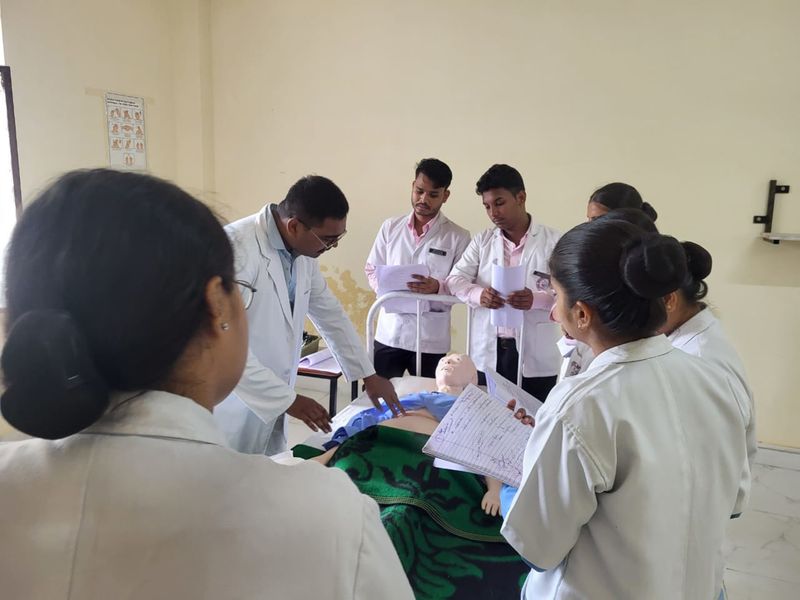 Students gathered around a training mannequin during a practical session