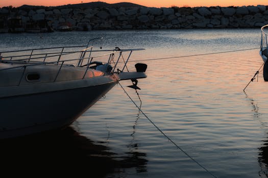 停泊在平静海面上的船只，随着太阳缓缓落下，倒映在水中