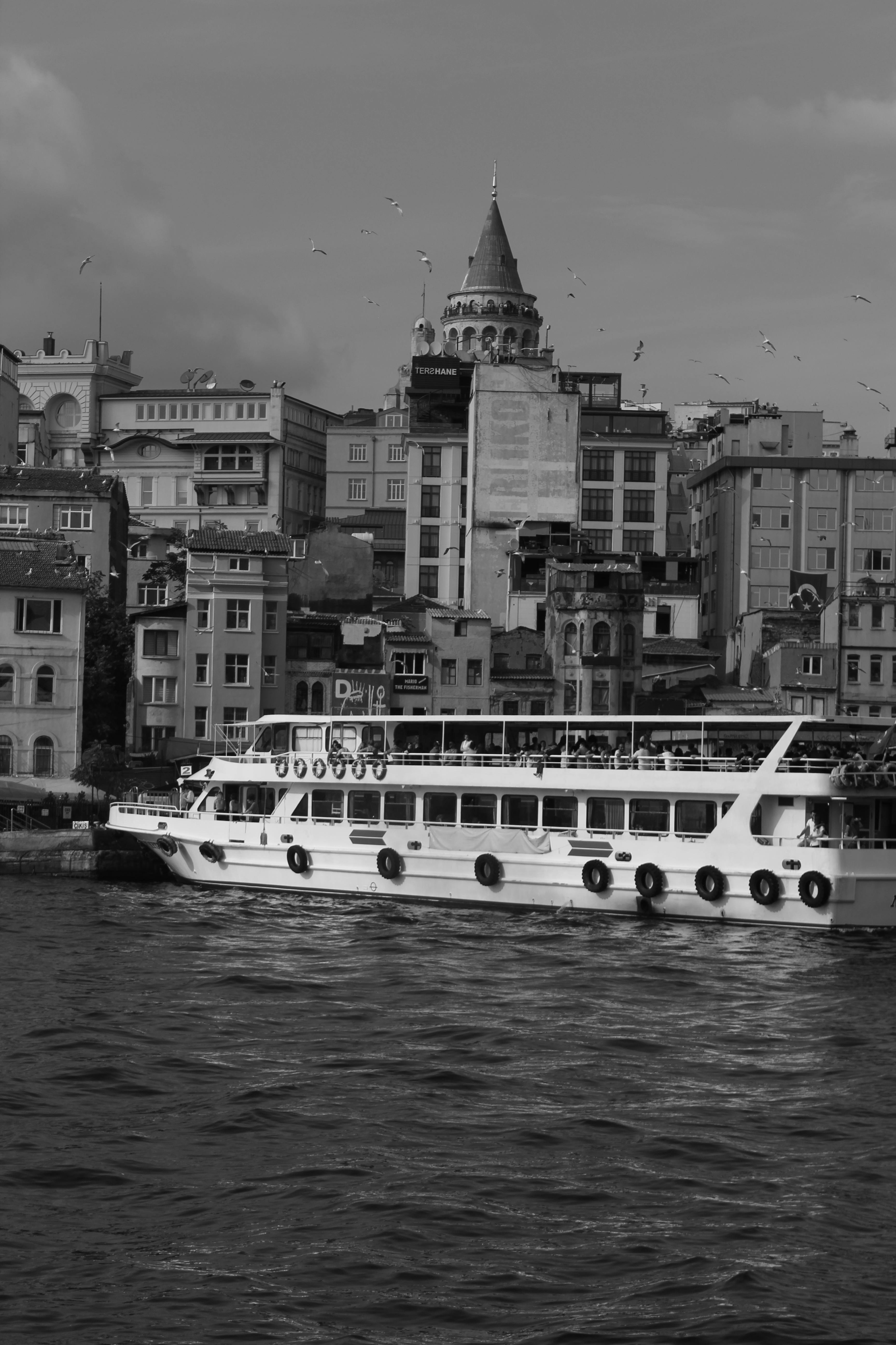 一张黑白照片记录了伊斯坦布尔博斯普鲁斯海峡上的标志性加拉塔塔和渡轮