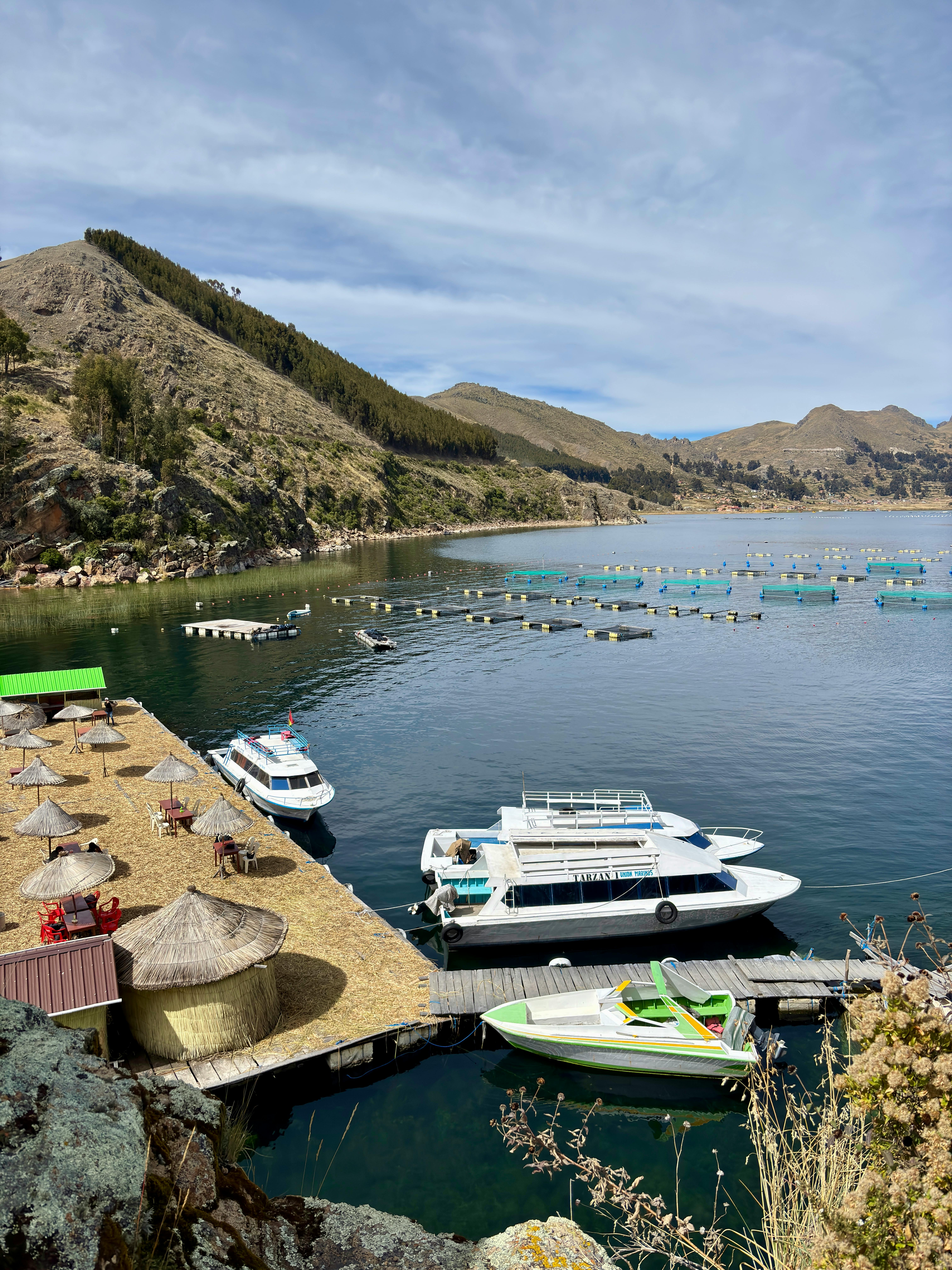 宁静的喀喀湖景观，在晴朗的天空下停泊着船只和山脉