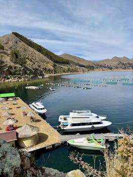 宁静的喀喀湖景观，在晴朗的天空下停泊着船只和山脉