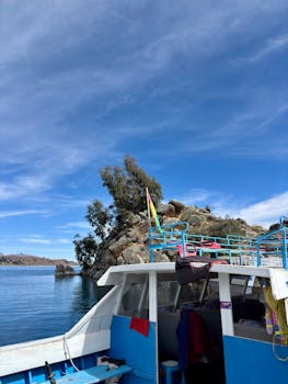 一个充满活力的船在的喀喀湖与岩石海岸和清澈的蓝天，提供了一个宁静的旅行体验