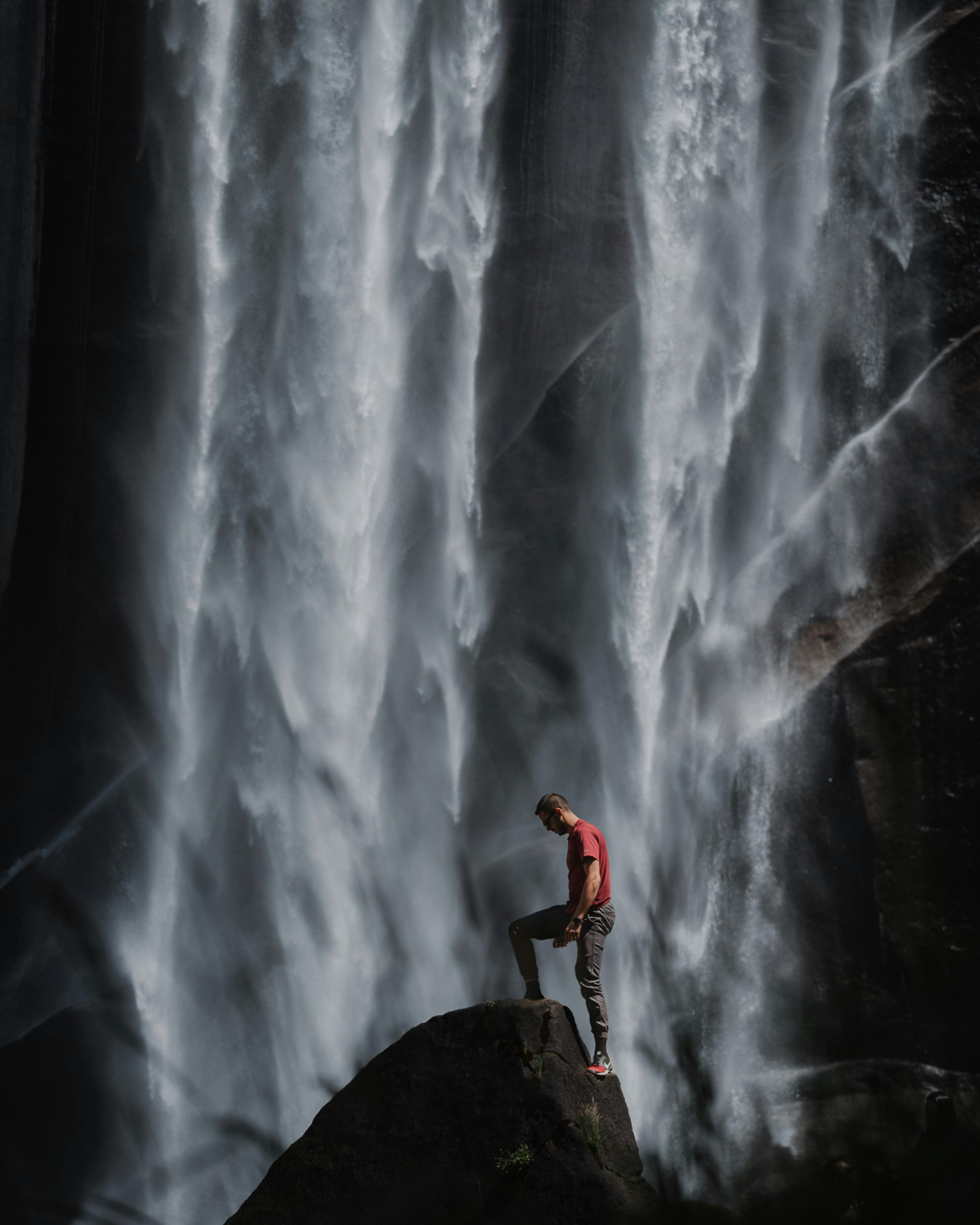 person in red shirt stepping on rock