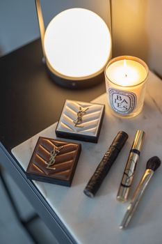 Luxurious makeup collection arrangement with candlelight ambiance.