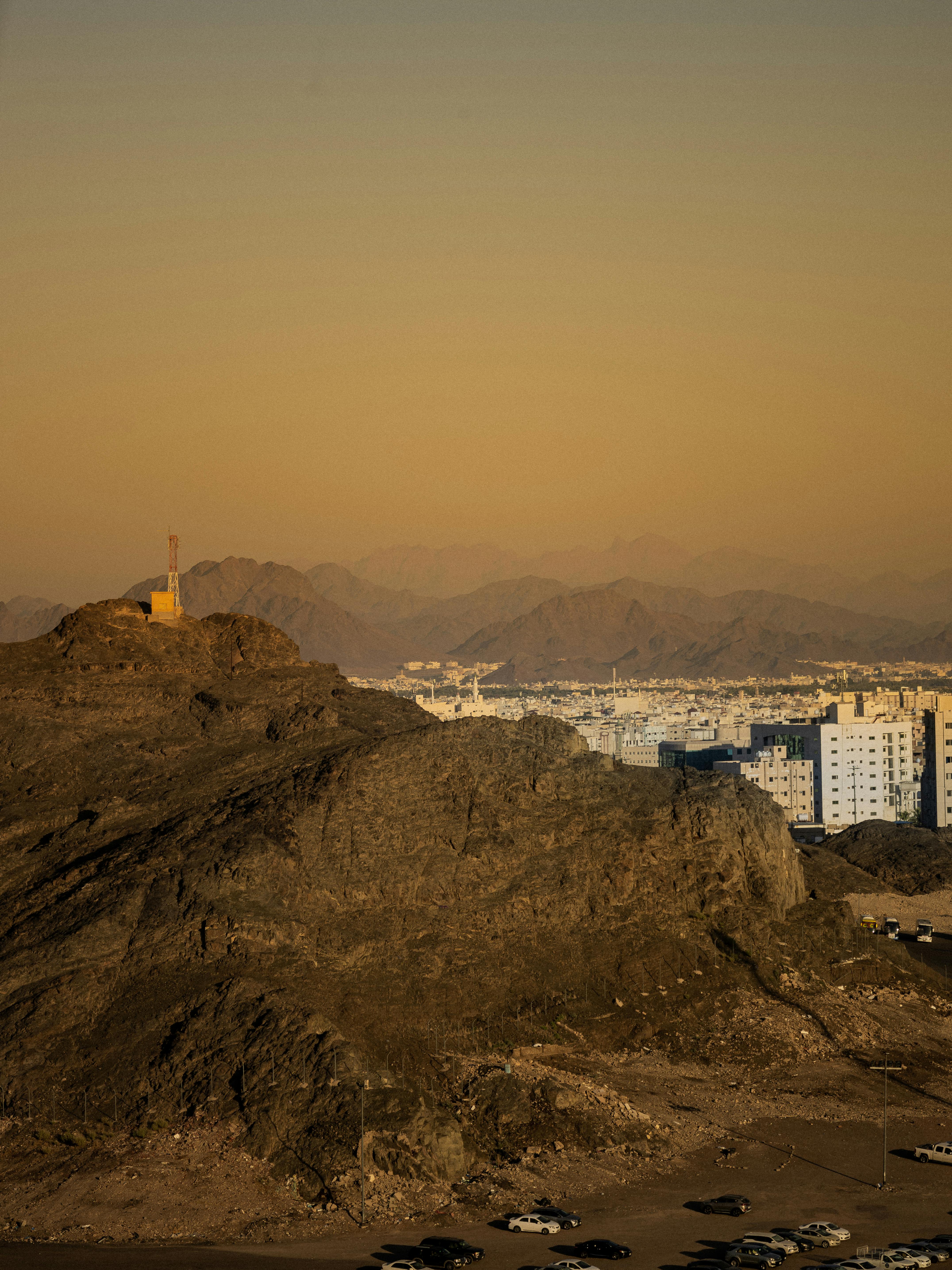 在温暖的夜空下，一座被崎岖山脉包围的城市的鸟瞰图