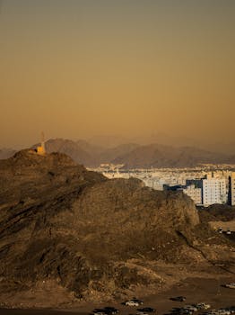 在温暖的夜空下，一座被崎岖山脉包围的城市的鸟瞰图
